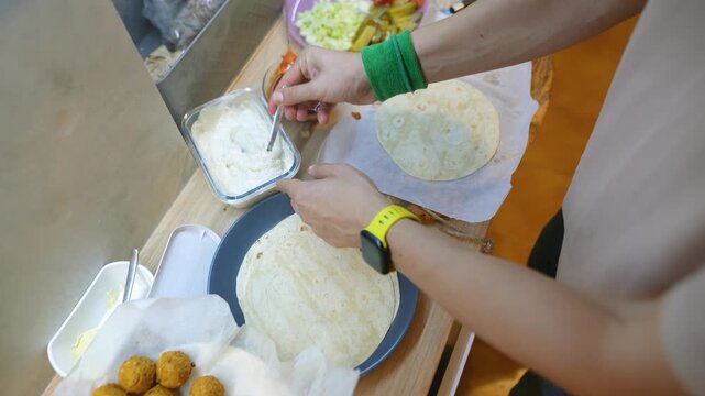 Applying gentle pressure to tortilla with toppings inside device