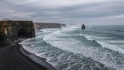 冬の曇天と荒波が断崖と海食柱を包む迫力の海岸風景