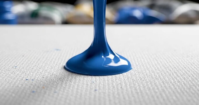 Blue paint brush on canvas closeup.