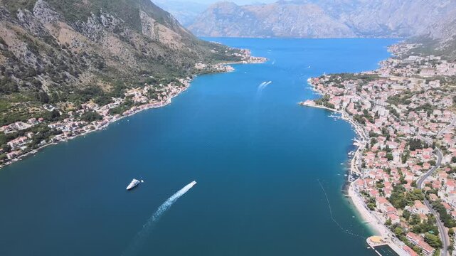 Breathtaking aerial drone footage over the Bay of Kotor (Boka Bay) in Montenegro, capturing the deep blue Adriatic waters surrounded by dramatic mountain landscapes. The video showcases the serene sea