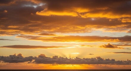 Obraz premium A vibrant sunset paints the sky with warm hues, sunlight bursting through the clouds over water