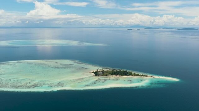 Aerial view of island Sibuan with sandy beach and coral reef. Tun Sakaran Marine Park. Borneo, Sabah, Malaysia.