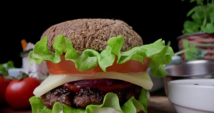 Tasty Burger with meat, cheese and vegetables, Hamburger of gluten free bun presentation snow motion video