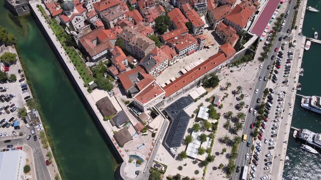 Detailed aerial drone footage featuring a close-up view of Kotor Old Town in Montenegro. The video captures the iconic red-tiled rooftops, medieval stone buildings, and narrow historic streets framed 