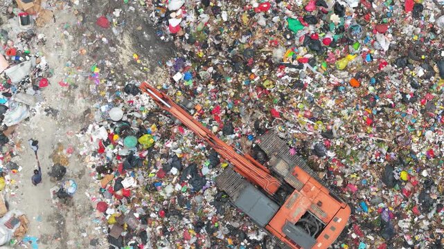 Aerial view of an excavator working in a landfill in bali
