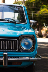 Fototapeta premium Front View of Blue Vintage Car with Classic Headlight and Grill