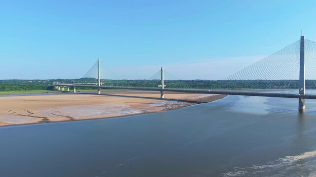Liverpool, Merseyside, UK, June 19, 2025; Aerial 4K video footage of the Mersey Gateway toll bridge with stunning views over the River Mersey, Liverpool, UK.
