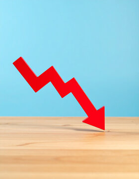 Red arrow pointing down, minimalist wooden graph, financial loss and business risk concept.