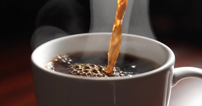 Coffee being poured into a white ceramic cup.