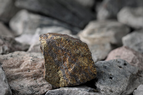 Copper (Cu) sulfide ore. Textured rock background. Mining critical, strategic mineral, raw material. Electronic, electrical, energy storage, wind and solar generation, plumbing, uses