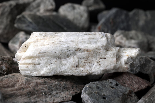 Lithium spodumene ore. Textured rock background. Critical strategic mineral, raw material. Used in lithium-ion battery cathode chemistries such as LCO, LFP, NMC