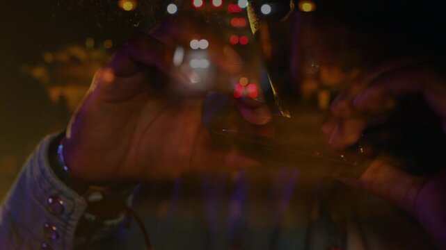 Animation of blurred night road traffic over caucasian man playing harmonica on concert