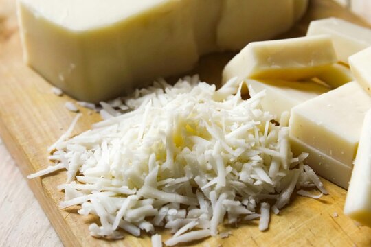 various shapes of cheese slices on a chopping board