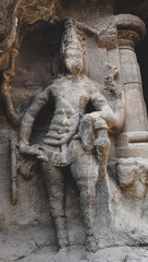 Obraz premium Monolithic standing guardian statue carved in basalt rock at Kailasa Temple, Ellora Caves.