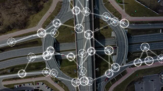 Aerial view of an urban multi-level intersection with many autonomous cars moving in different directions. Vehicles controlled by artificial intelligence. Smart cars with HUD-elements. 4k footage