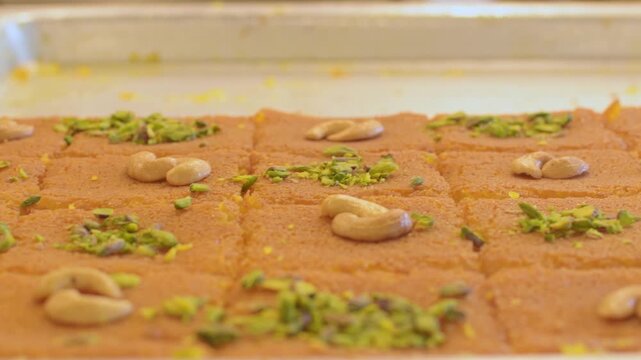 Close up view Jordan traditional fresh knafeh dessert with melted cheese semolina crust sugar syrup pistachio cashew topping Middle East street food close up