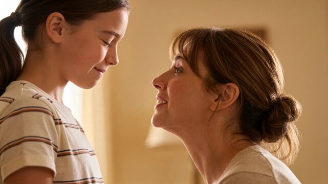 Crouching mom meeting daughter, leaning in speaking softly, comforting at home, lamp, striped tee