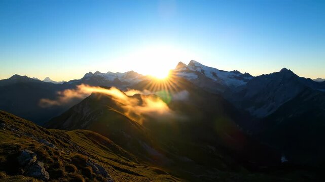 Mountains peek through morning fog, a scenic landscape with snow-capped peaks in the dusk. Moody mountain landscape scenery.