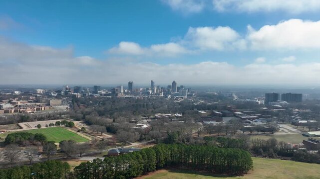 Downtown Raleigh skyline from Dorothea Dix Park with open fields and trees in foreground.