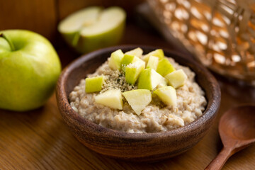 Cooked oatmeal porridge with green apple and hemp seeds. Healthy vegan breakfast meal