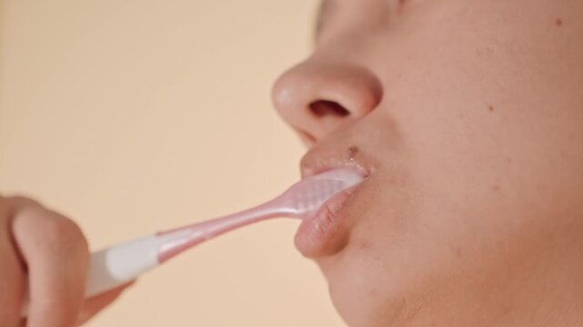 Hotel guest brushes sink vigorously. Guest prepares for day with intense brush and minty breath. Hotel guest performs deep cleaning at bathroom sink with energetic strokes and fresh breath