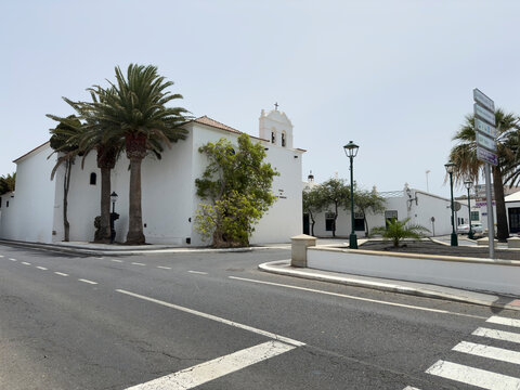 White buildings with palm trees and a church.. Yaiza, Lanzarote, Spain