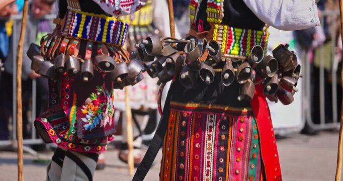 Bulgarian Kukers with bells and traditional costumes, masked people kukeri dancing in masquerade festival Kukerlandia, Yambol, Bulgaria