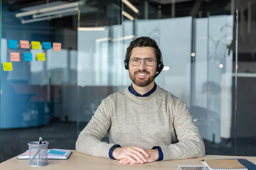 Obraz premium Happy male support agent wearing headset in office