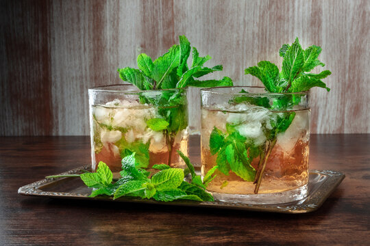 Mint Julep, the classic Kentucky Derby cocktail, with fresh mint and crushed ice, side view on rustic textures