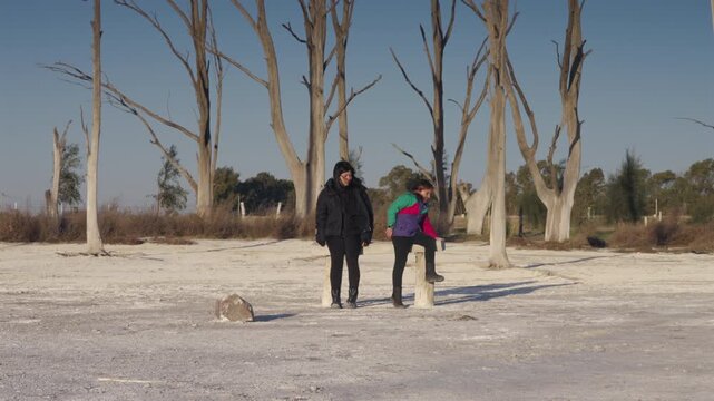 Little girl running to sit beside her mother to Sharing Joyful Moment in snowy setting, Parenthood