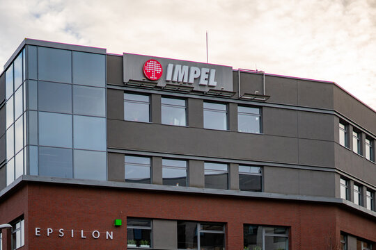 Modern Epsilon office building featuring Impel Group logo on facade, contemporary brick and glass corporate architecture, business center headquarters in Poland, commercial real estate exterior under 