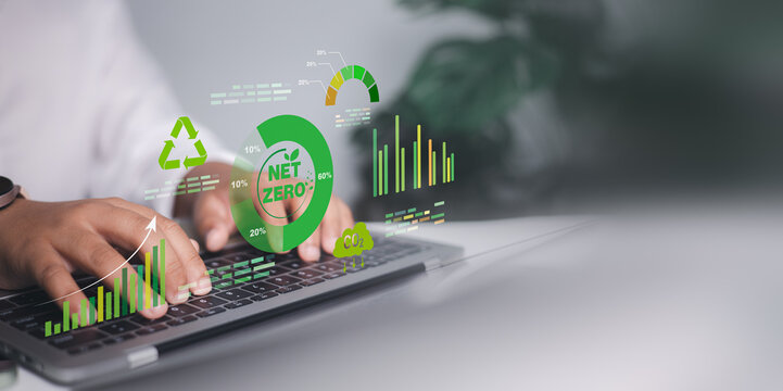 Close up of hands typing on laptop with green net zero and carbon neutral graphics for sustainable business, environmental social and governance ESG goals, eco friendly corporate strategy.