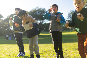 Fototapeta premium Young boys blowing bubbles having fun outdoors