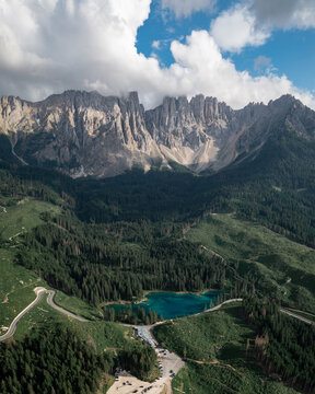 Aerial view of the crystalline blue lake nestled amidst the dense forest and majestic Dolomites, Trentino-South Tyrol, Lago Di Carezza, Italy.