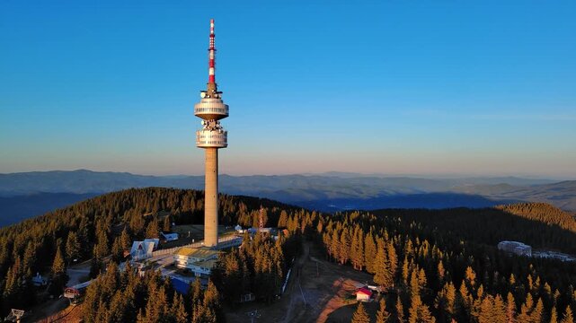 Tower Snezhana on peak of Snezhana covered with spruce forests in Rhodope mountains