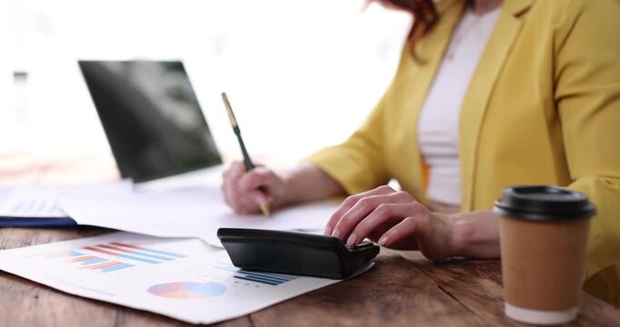 Business woman pointing at a clipboard with financial charts and graphs, effectively communicating business analysis and market trends in an office setting
