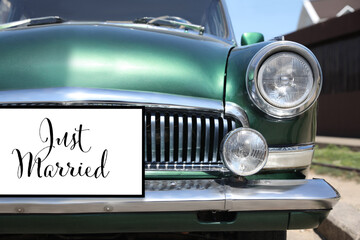 Fototapeta premium Just Married sign on retro car outdoors, closeup. Wedding tradition