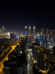 Fototapeta premium Fantastic nighttime skyline of a big city with illuminated skyscrapers, Dubai financial district at night, United Arab Emirates, aerial view.