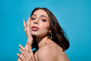 Young woman exudes elegance and style against a vibrant blue backdrop