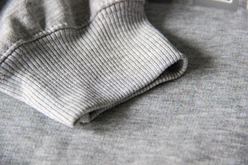 Close up of heather gray sweatshirt cuff with rib knit texture, casual clothing fabric detail © Ramadhan