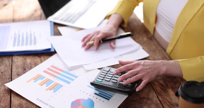 Business woman pointing at a clipboard with financial charts and graphs, effectively communicating business analysis and market trends in an office setting

