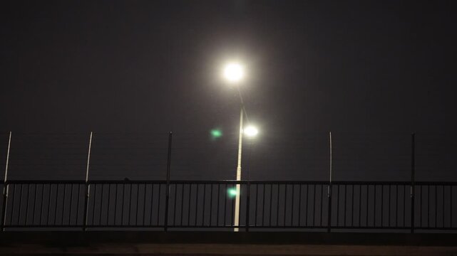 Stockholm, Sweden A bicyclist at night passes under a street lamp on the Western Bridge.
