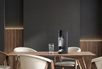 Matte black soda maker with sparkling water on walnut dining table