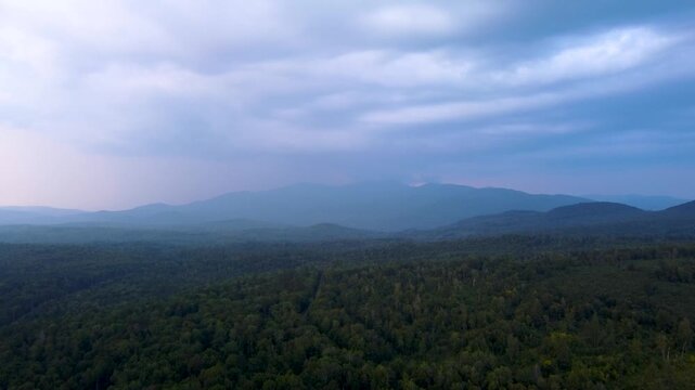 Maidstone, Vermont, an aerial view of the dense northern forest and rolling green mountains of the Northeast Kingdom after sunset.
