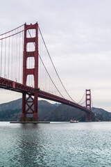 Obraz premium Vertical view of Golden Gate Bridge tower with water reflection in San Francisco