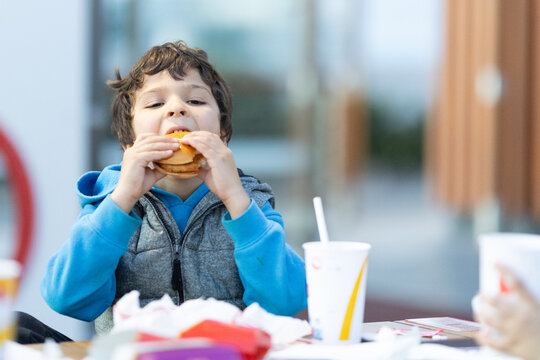 Young boy eating fast food hamburger meal