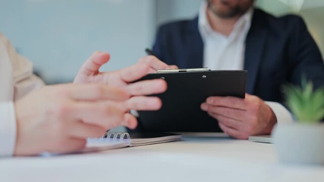 Professionals engage in focused business meeting, reviewing documents and discussing project details. Demonstrating professionalism and engagement, atmosphere of cooperation, collaboration evident.