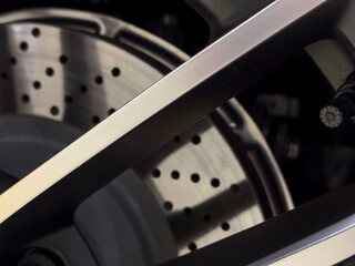 Dramatic macro shot of a car wheel, highlighting the brake disc and the metal accents of the wheel....