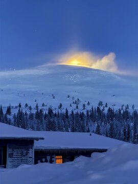 Snow sweeps over the fells in front of the moon at twilight, Hotel Pallas, Pallas-Yll&auml;stunturi National Park, Lapland, Finland