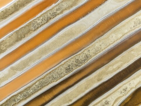 Saline ponds at the salt works near Chiclana de la Frontera. The orange-red colour depends on the level of salinity and is directly caused by the algae Dunaliella salina and brine shrimp. Aerial view. Drone shot. C&aacute;diz province, Andalusia, Spain